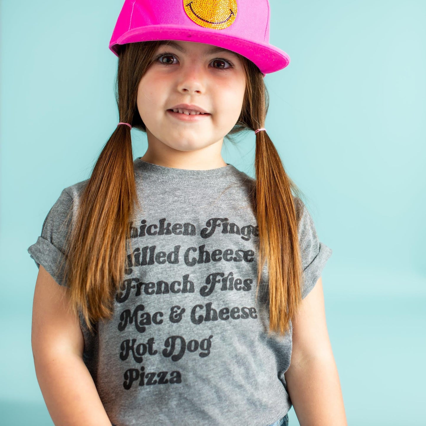 girl wearing a grey Kids Menu T-Shirt and a pink hat