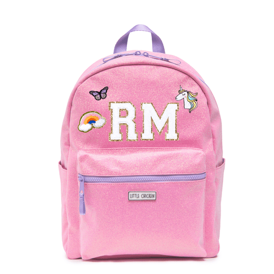 Pink backpack with 'RM' initials, a rainbow, butterfly, and unicorn patch on a white background.