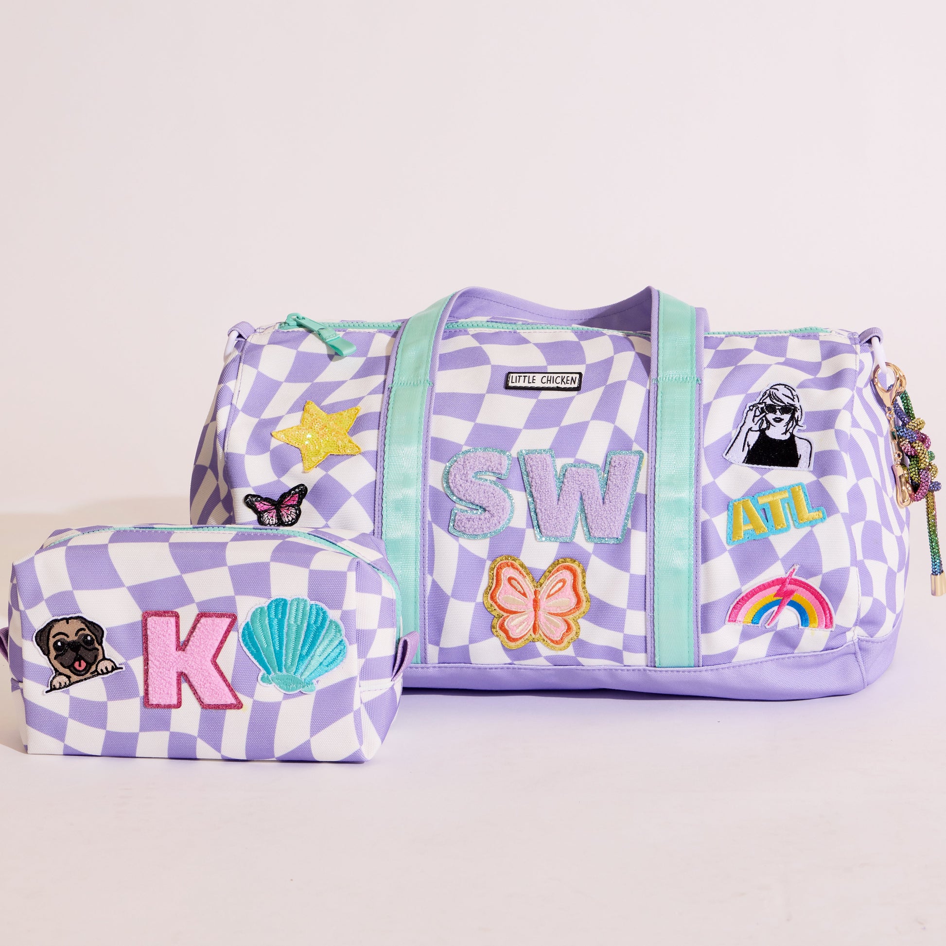 custom Purple checkered duffel bag with patches and a matching pouch on a light gray background