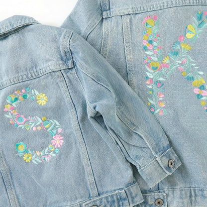 Light blue denim jacket with floral embroidery on a matching fabric background