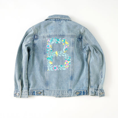 Denim jacket with floral embroidery on a white background