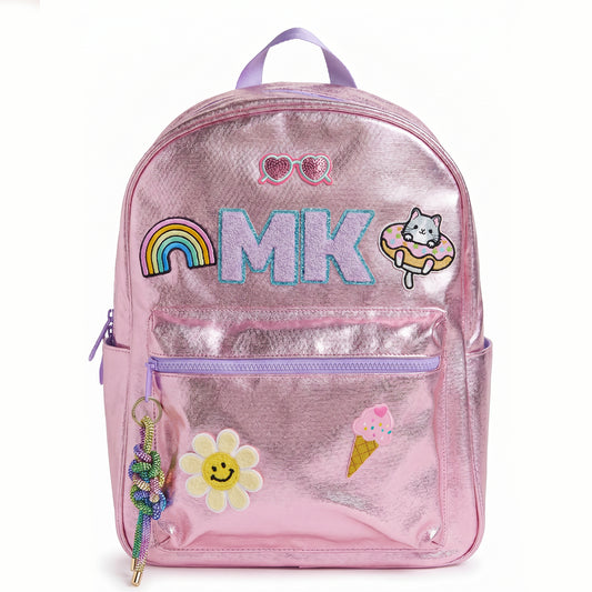 Personalized metallic pink kids backpack with custom initials and colorful patches including a rainbow, smiley flower, cat, ice cream cone and heart sunglasses. Features a front zip pocket, side pockets and spacious storage for school, camp and travel.