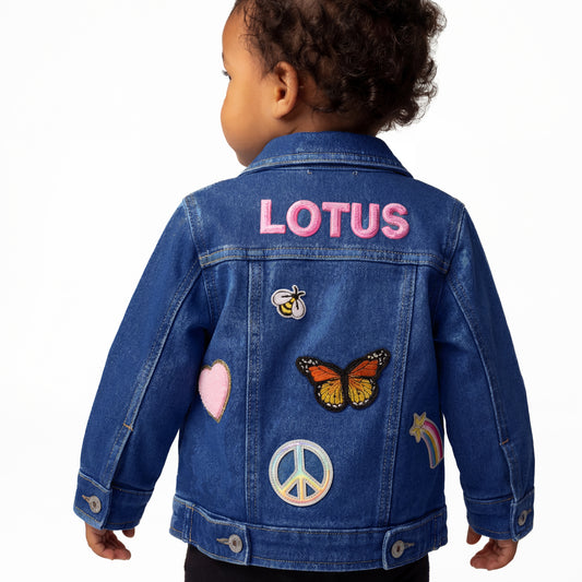 baby wearing a denim jacket with patches and 'LOTUS' branding on a white background