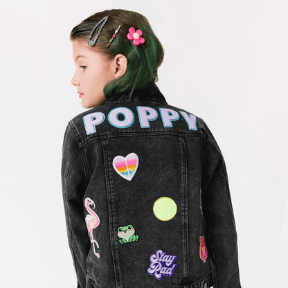 kid in a custom black denim jacket with colorful patches and monogram name