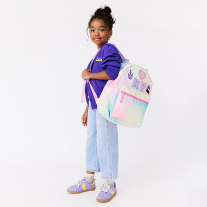 girl holding a rainbow backpack. personalized backpack