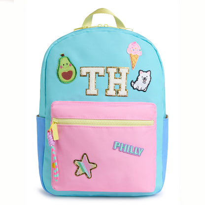 Personalized pastel kids backpack featuring custom initial patches, avocado, ice cream, puppy, star and city name patches. Includes front zip pocket, side pockets and spacious storage for school, camp and travel.
