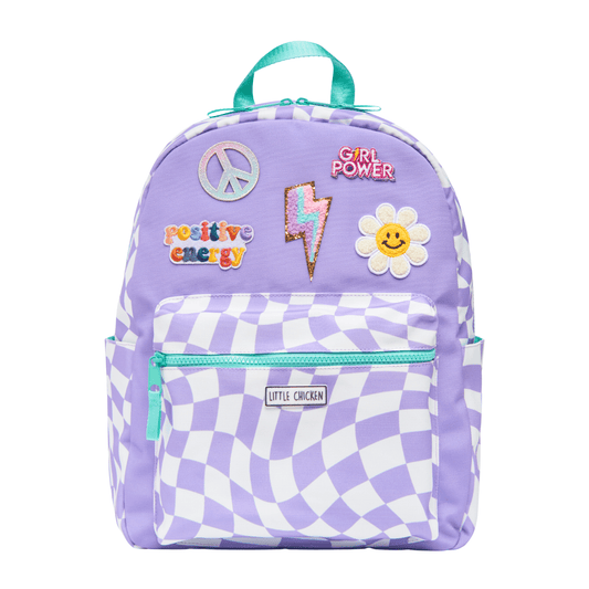 Purple backpack with checkered pattern and various patches on a white background