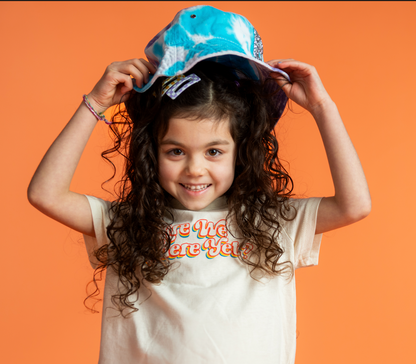 little girl putting on a Custom Bucket Hat